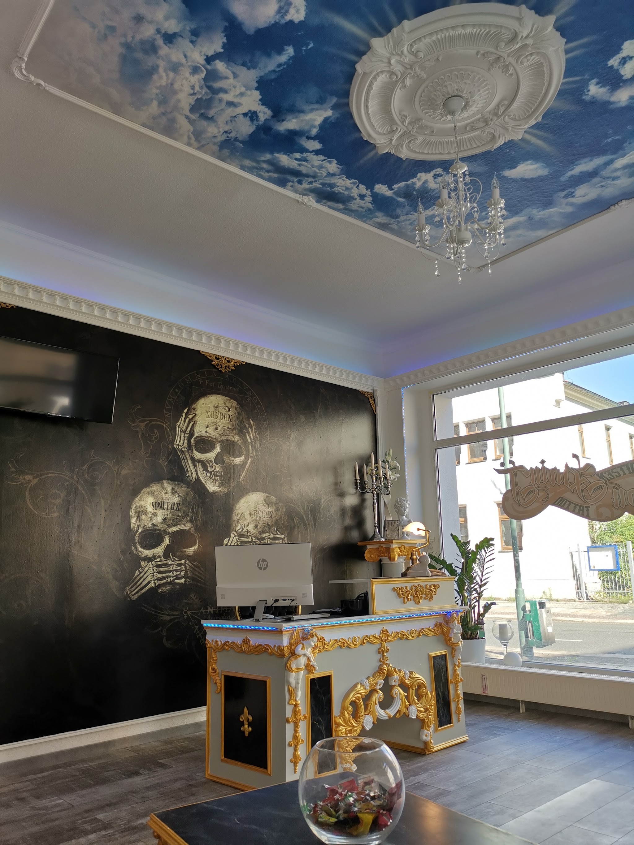 Empfangsbereich des IronPainT Tattoo-Studios mit Deckenmalerei